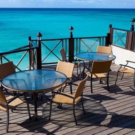 tables on a deck surrounded by blue water
