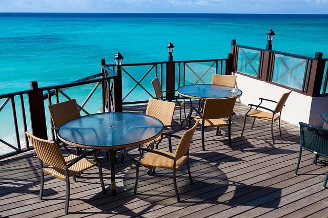 tables on a deck surrounded by blue water